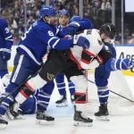 Dec 27, 2025; Toronto, Ontario, CAN; Toronto Maple Leafs defenseman Chris Tanev (8) clears Ottawa Senators forward Brady Tkachuk (7) away from the front of the net during the second period at Scotiabank Arena.