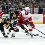 Dec 28, 2022; Pittsburgh, Pennsylvania, USA; Detroit Red Wings center Dylan Larkin (71) skates with the puck against Pittsburgh Penguins defenseman Marcus Pettersson (28) and center Sidney Crosby (87) during the first period at PPG Paints Arena.
