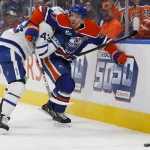 Oct 24, 2026; Edmonton, Alberta, CAN; Edmonton Oilers forward Connor McDavid (97) and Toronto Maple Leafs defensemen Darren Raddysh (43) battle along the boards for a loose puck during the first period at Rogers Place.