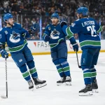 Oct 1, 2026; Vancouver, British Columbia, CAN; Vancouver Canucks forward Paul Cotter (47) celebrates his goal with defenseman Luke Schenn (2) and defenseman Elias Pettersson (25) against the Edmonton Oilers in the second period at Rogers Arena.